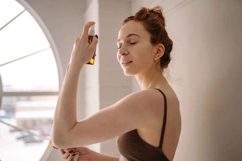 Woman applying Water Locking Mist facial spray to hydrate skin before makeup.